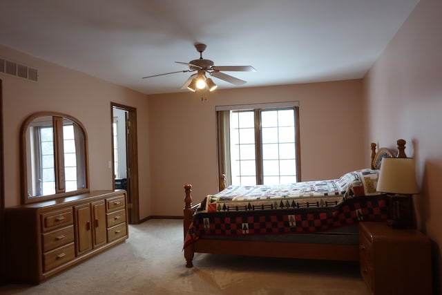 bedroom featuring ceiling fan, light colored carpet, and multiple windows