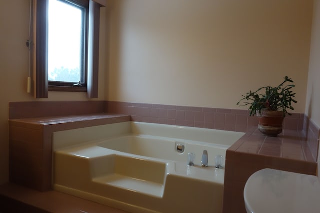 bathroom with a tub to relax in and a wealth of natural light