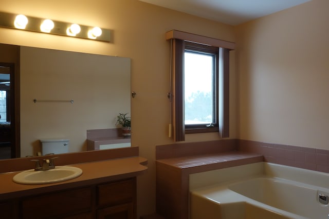 bathroom featuring a bathing tub, vanity, and toilet