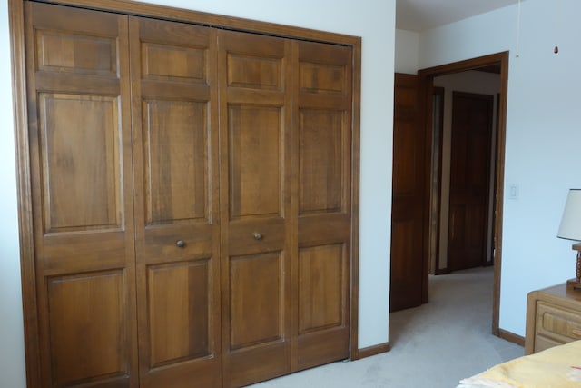 unfurnished bedroom featuring light colored carpet and a closet