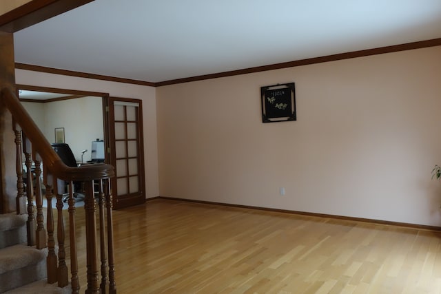 unfurnished room featuring ornamental molding and light wood-type flooring