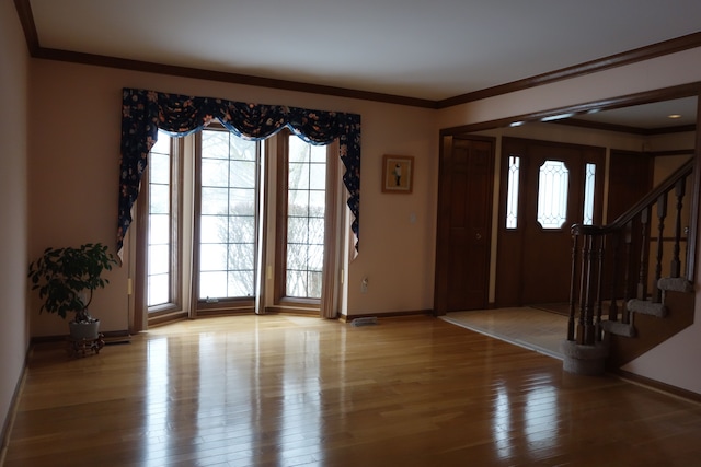 foyer with ornamental molding and wood-type flooring