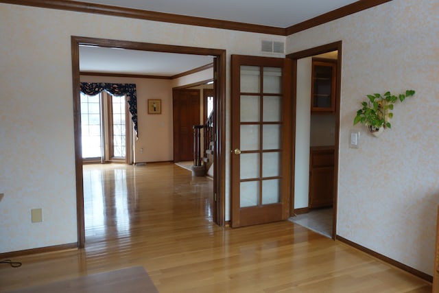 empty room with ornamental molding and light hardwood / wood-style flooring