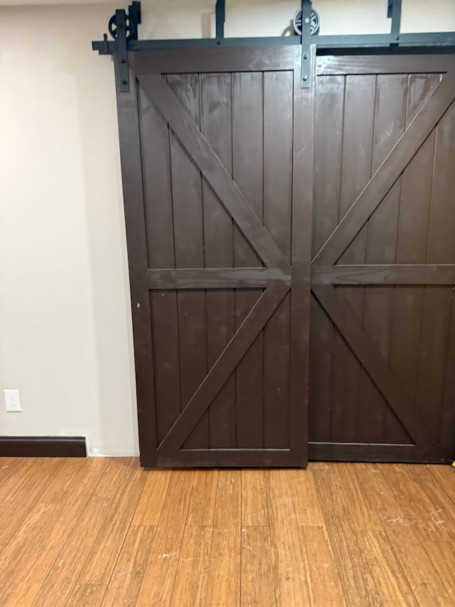 room details with a barn door and hardwood / wood-style floors