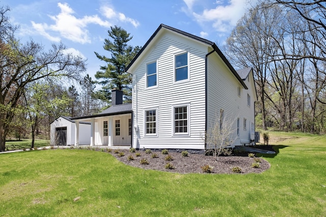 101 Carl Dr NE, Ada, MI 49301 - rear view of house with a lawn, a chimney, and an attached garage