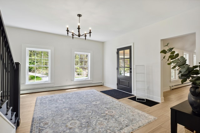 101 Carl Dr NE, Ada, MI 49301 - entryway with baseboard heating, a chandelier, and light wood-style flooring
