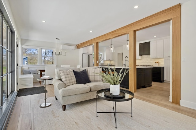 101 Carl Dr NE, Ada, MI 49301 - living room with light wood-style floors, a wall unit AC, a chandelier, and recessed lighting