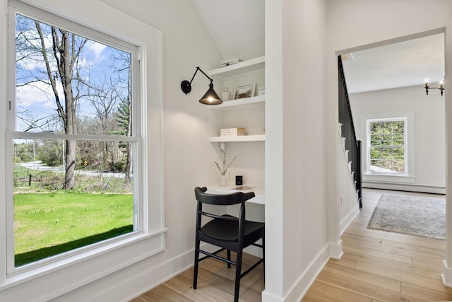 101 Carl Dr NE, Ada, MI 49301 - corridor with a baseboard heating unit, healthy amount of natural light, light wood-style floors, baseboards, and lofted ceiling