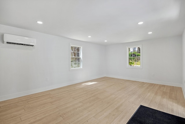 101 Carl Dr NE, Ada, MI 49301 - unfurnished room with a wall mounted air conditioner, light wood-style floors, recessed lighting, and baseboards