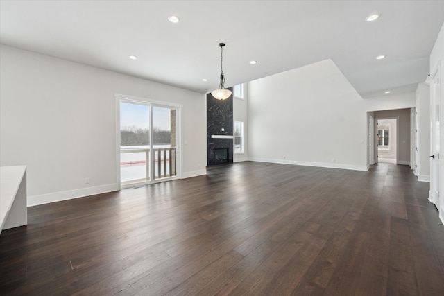 unfurnished living room with dark hardwood / wood-style flooring and a fireplace