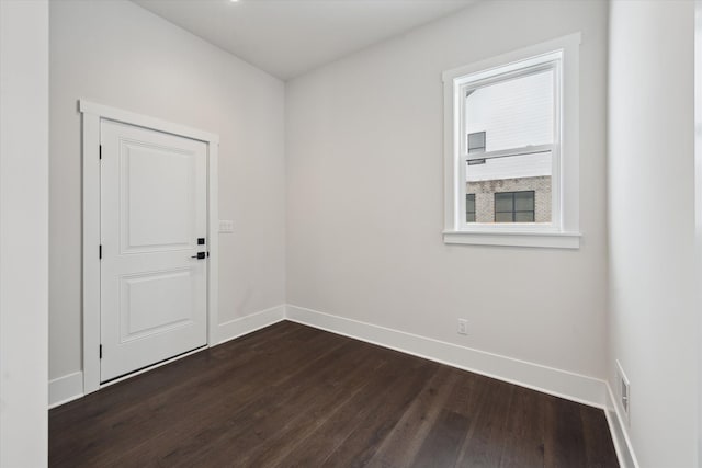 spare room with dark hardwood / wood-style flooring