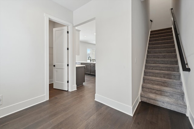 stairs featuring hardwood / wood-style flooring and sink