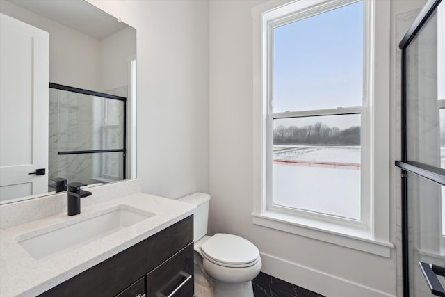 bathroom featuring an enclosed shower, vanity, a wealth of natural light, and toilet