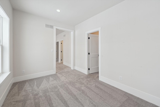 spare room featuring light colored carpet