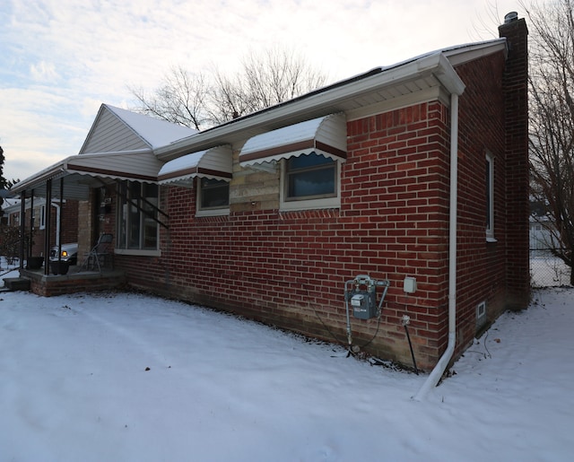 snow covered property featuring covered porch