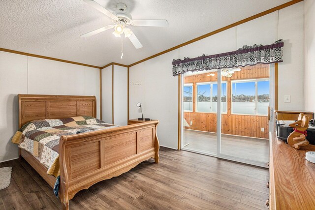bedroom featuring crown molding, hardwood / wood-style flooring, ceiling fan, access to exterior, and a textured ceiling