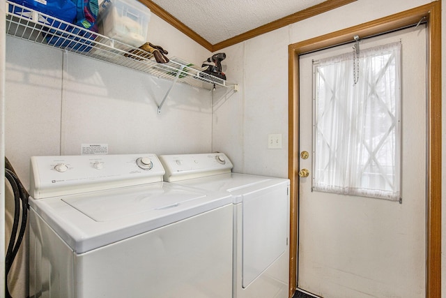 laundry room featuring crown molding, washing machine and clothes dryer, and a textured ceiling