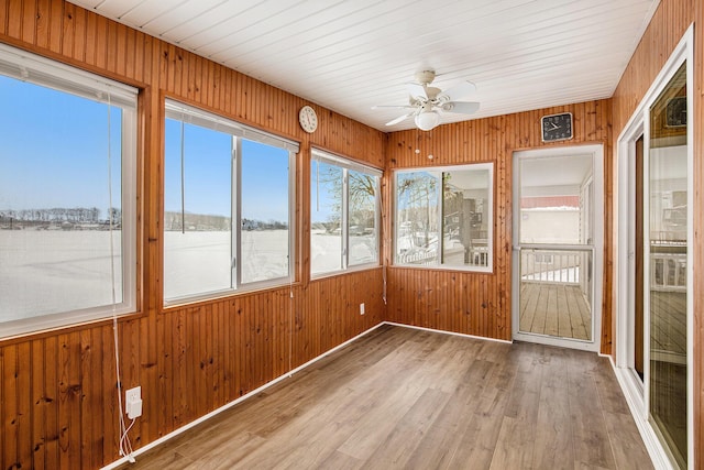 unfurnished sunroom featuring ceiling fan