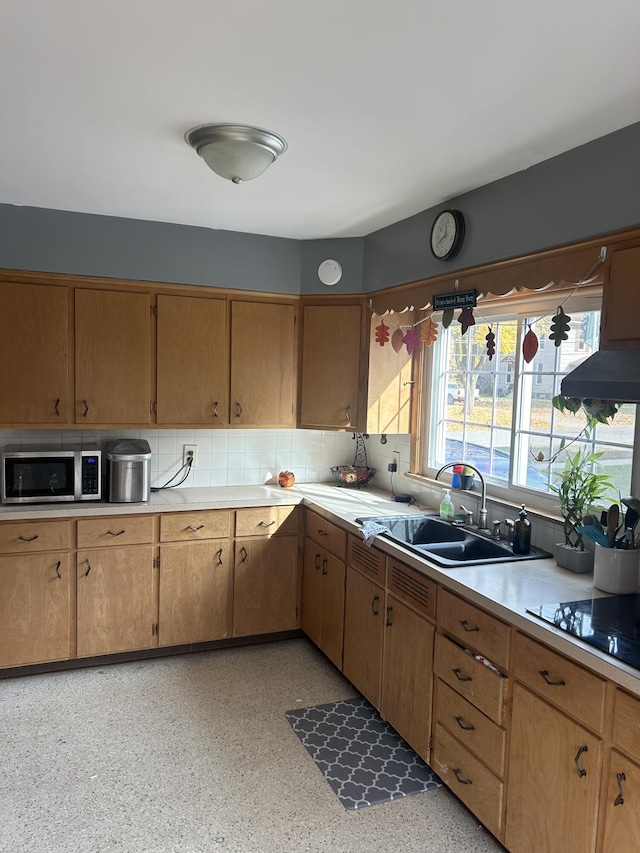 kitchen featuring sink, decorative backsplash, and black electric stovetop