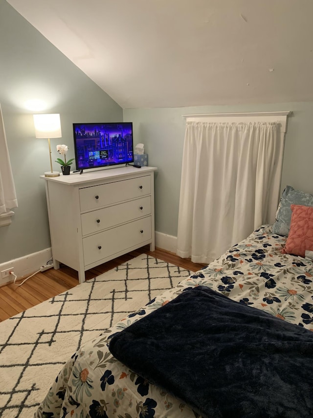 bedroom with lofted ceiling and light hardwood / wood-style floors