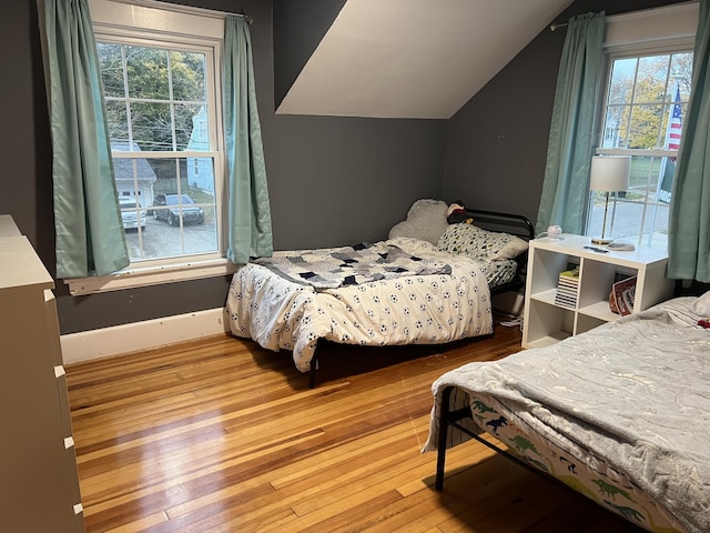 bedroom with hardwood / wood-style flooring and lofted ceiling