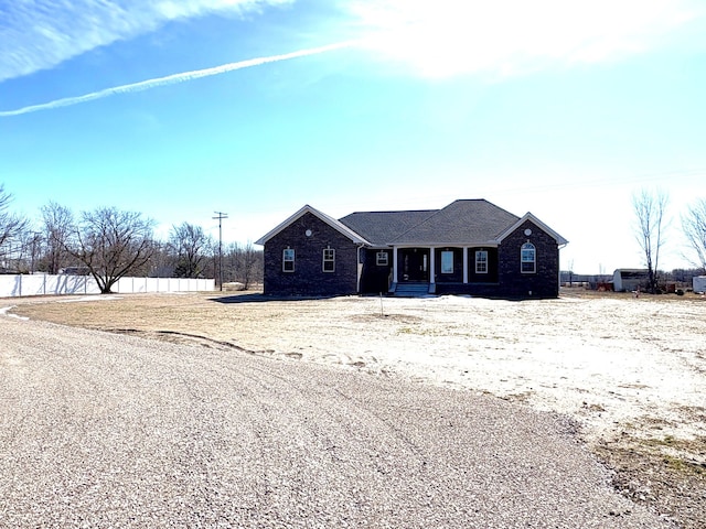 ranch-style house featuring fence