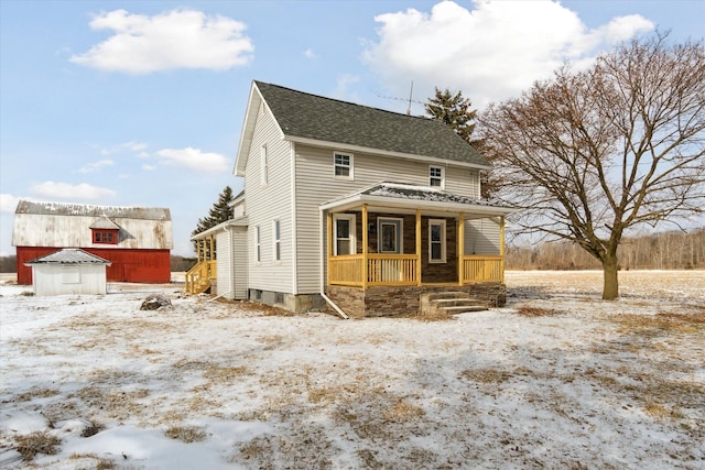 view of front facade featuring a porch and a storage unit