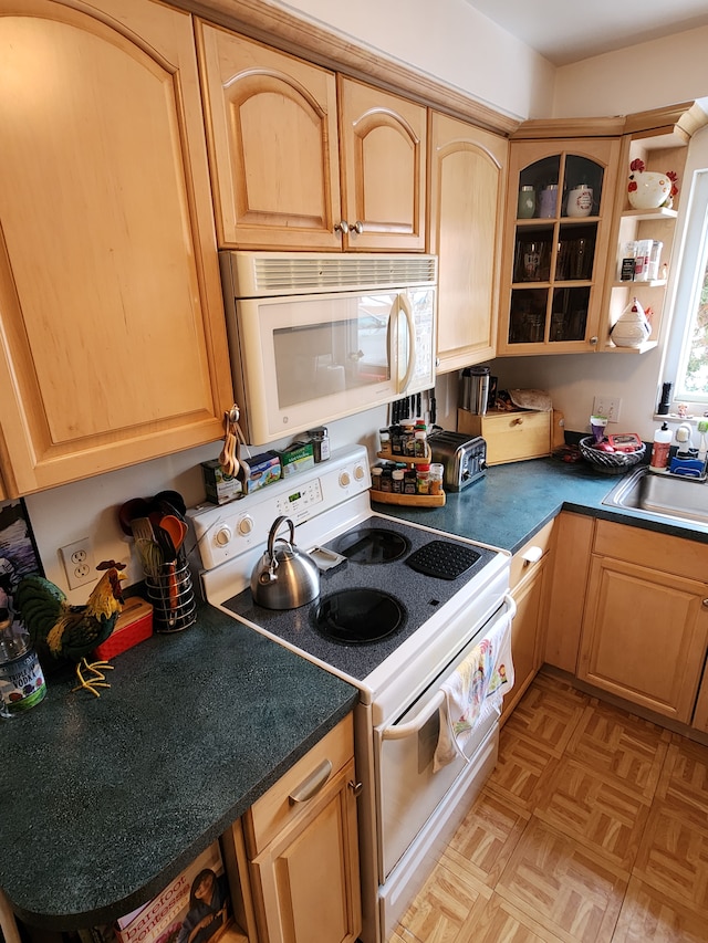 kitchen featuring light parquet floors, sink, light brown cabinetry, and white appliances