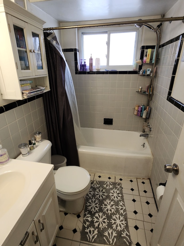 full bathroom with toilet, tile walls, vanity, shower / bath combo with shower curtain, and backsplash