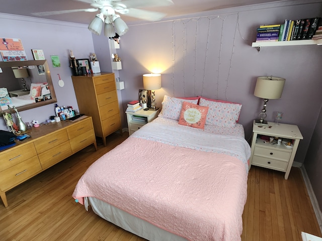 bedroom with hardwood / wood-style flooring, crown molding, and ceiling fan