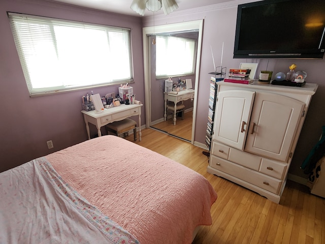 bedroom with ornamental molding, a closet, ceiling fan, and light hardwood / wood-style flooring