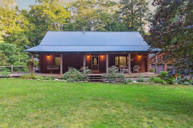 rear view of property featuring a yard and covered porch