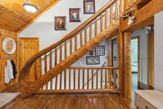 stairs featuring lofted ceiling, wood-type flooring, and wooden ceiling