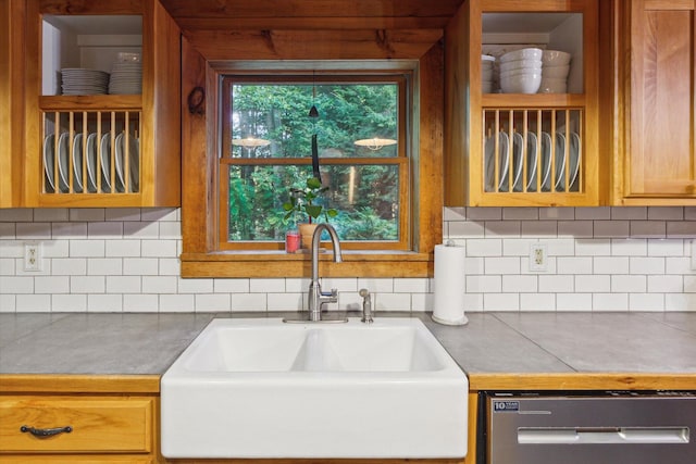 kitchen featuring tasteful backsplash, dishwasher, and sink