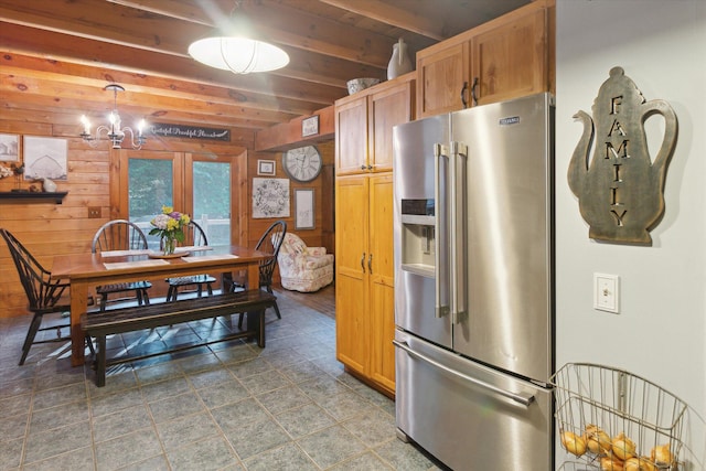 kitchen featuring high quality fridge, wood walls, beamed ceiling, a chandelier, and hanging light fixtures