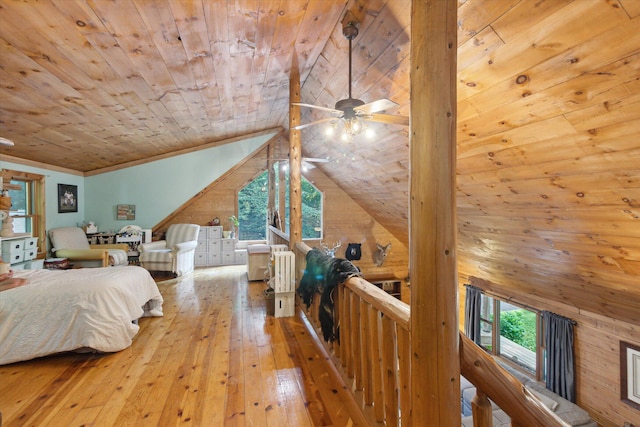 bedroom featuring lofted ceiling, wood walls, light hardwood / wood-style flooring, wooden ceiling, and multiple windows