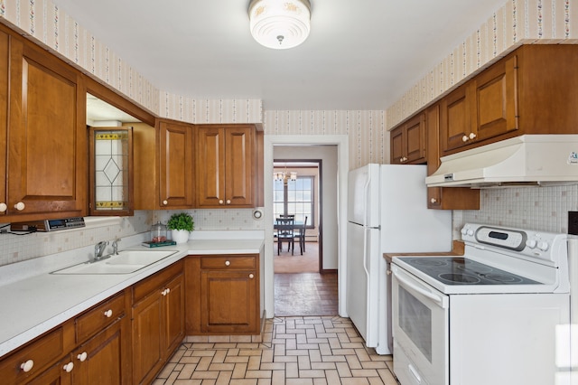 kitchen with a notable chandelier, white electric range oven, sink, and backsplash