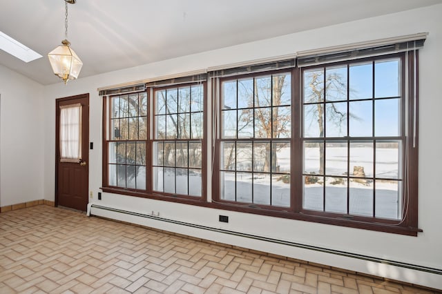 doorway to outside featuring a baseboard heating unit and vaulted ceiling with skylight