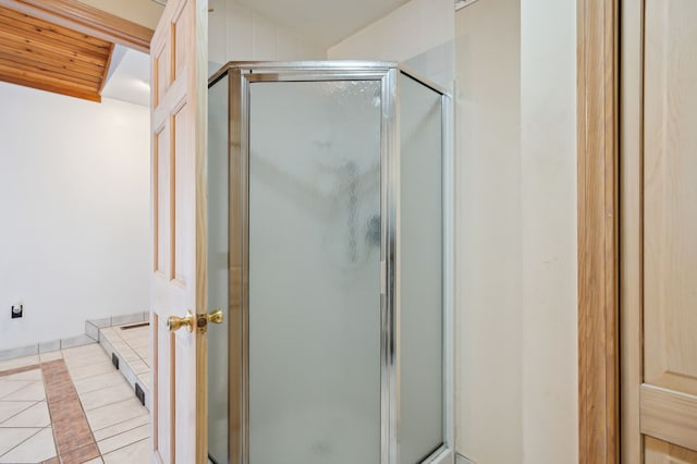 bathroom with tile patterned flooring, vaulted ceiling, and walk in shower