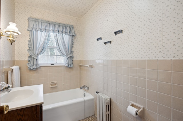 bathroom with vanity, radiator heating unit, tile walls, and a bathing tub