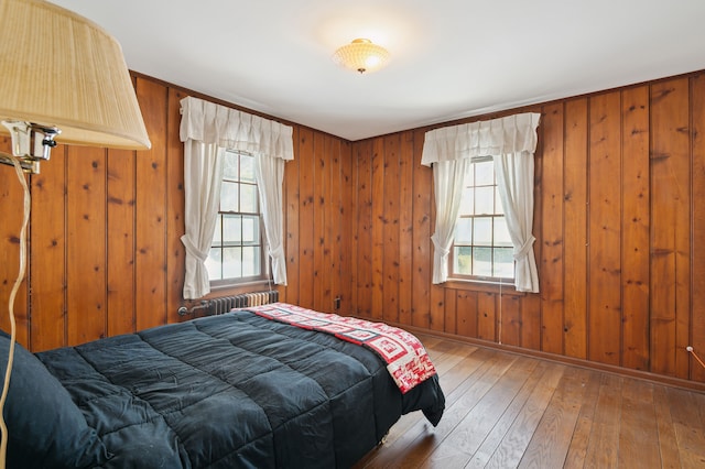 bedroom featuring wood-type flooring and wooden walls