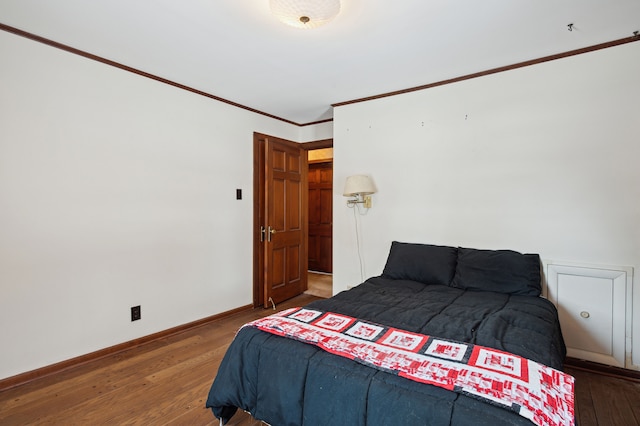 bedroom featuring dark hardwood / wood-style flooring and ornamental molding