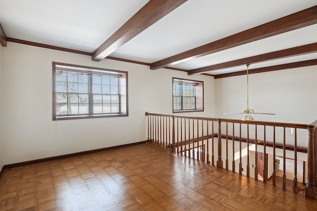 unfurnished room featuring parquet floors and beam ceiling