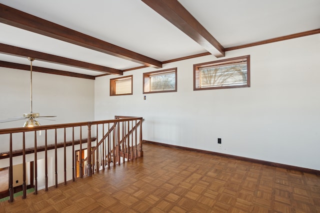 spare room featuring beam ceiling, dark parquet floors, and ceiling fan