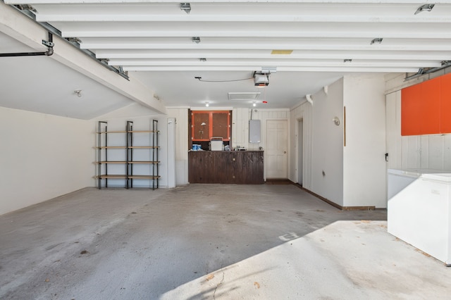 garage with a garage door opener, electric panel, and independent washer and dryer