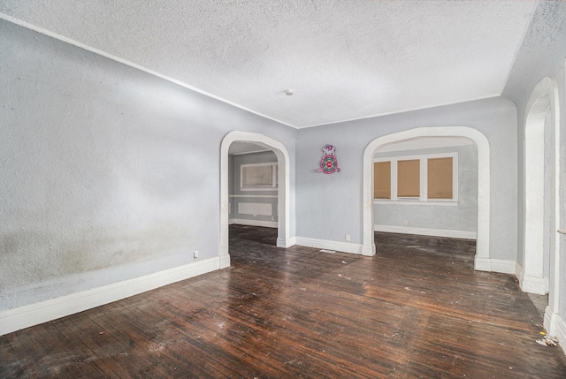 empty room with dark hardwood / wood-style floors and a textured ceiling