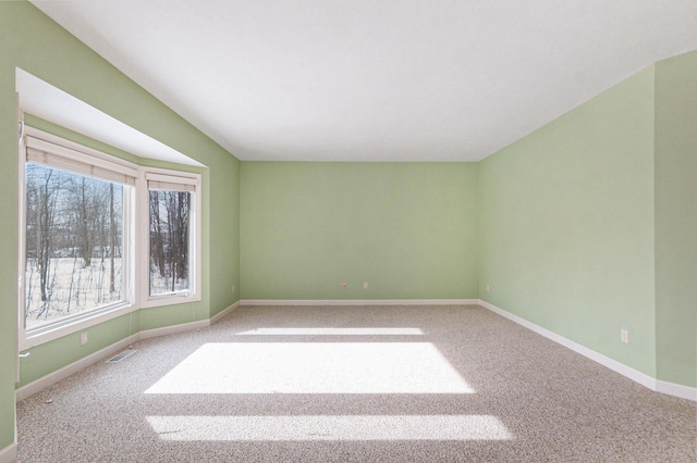 empty room featuring visible vents, carpet, and baseboards