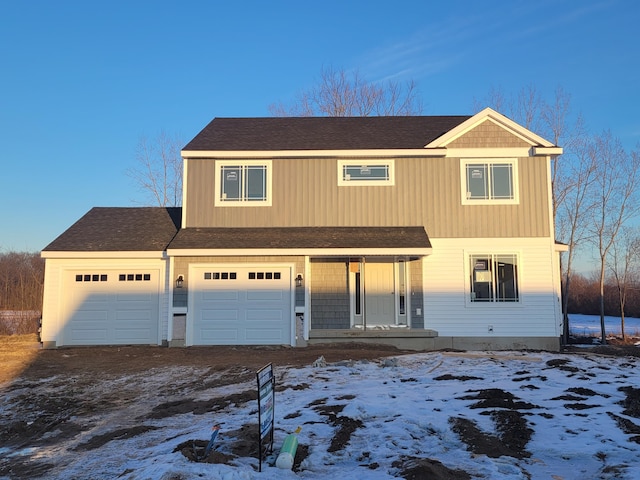 view of front of home with a garage, dirt driveway, and a shingled roof