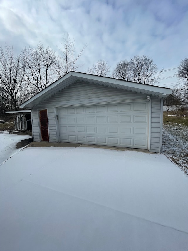 snow covered garage with a garage