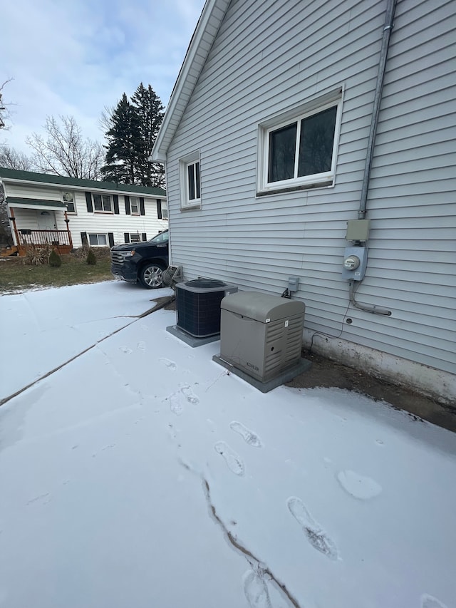 view of snow covered exterior featuring central AC